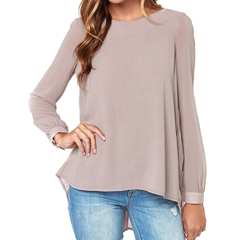 Blusa de chifón beige con cuello en V, manga larga y caída suave, combinada con jeans.