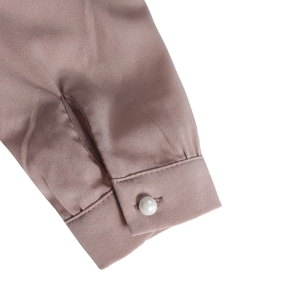 Puño de manga larga en blusa de chifón rosa suave con botón perla.