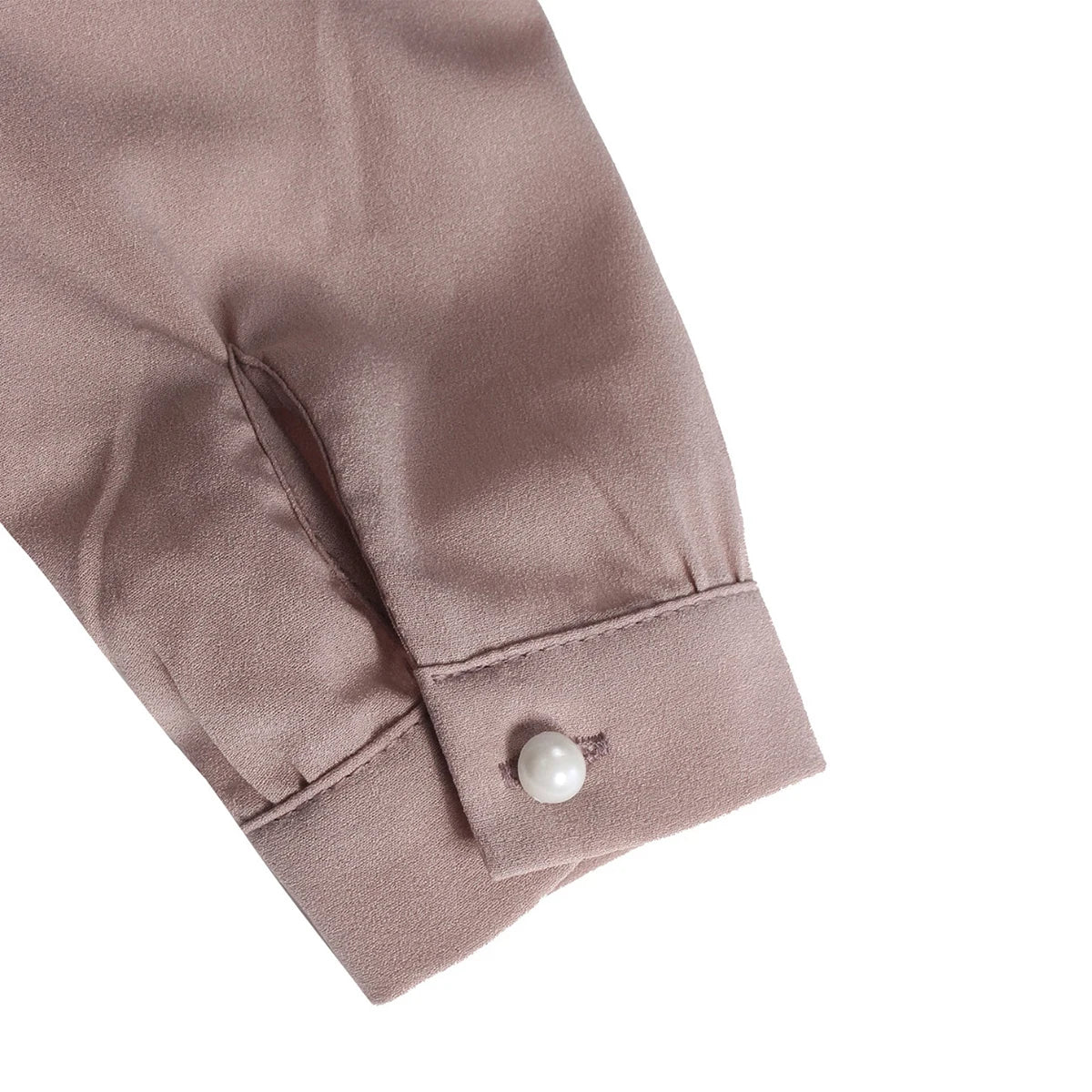 Puño de manga larga en blusa de chifón rosa suave con botón perla.